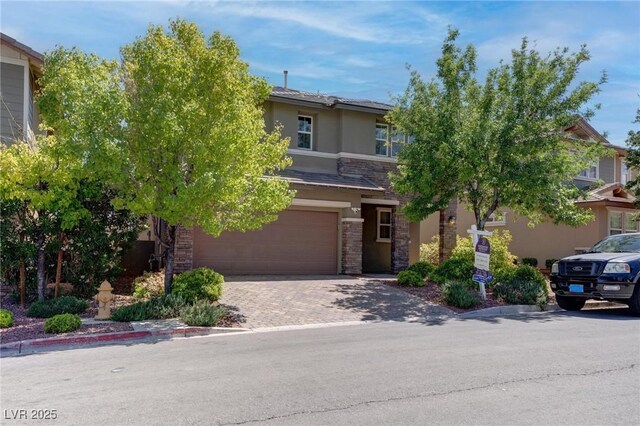 10273 Aragon Crown Rd, Las Vegas, NV 89135 - obstructed view of property featuring stucco siding, an attached garage, stone siding, and decorative driveway