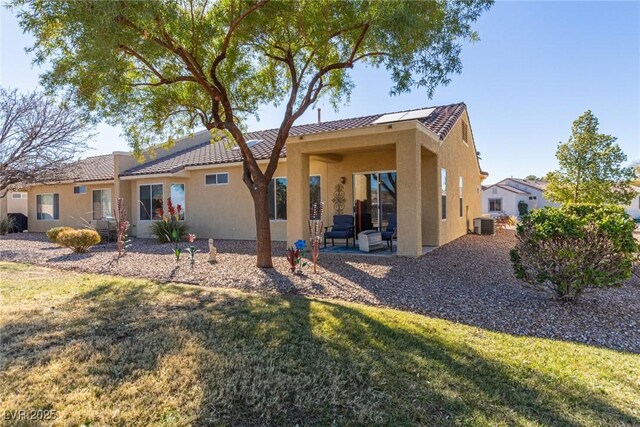 back of property with a patio, central air condition unit, and a yard