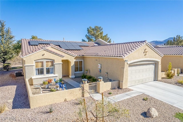 view of front of home with cooling unit, solar panels, and a garage