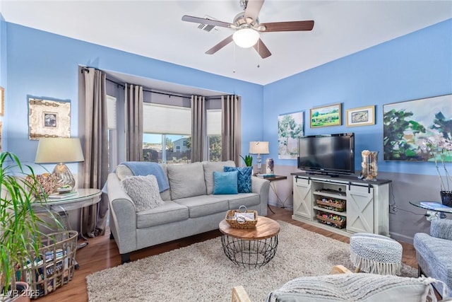 living room featuring wood-type flooring and ceiling fan