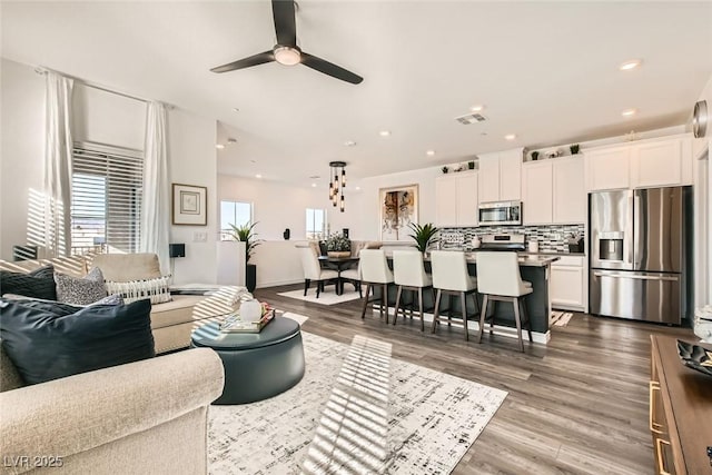 living room with hardwood / wood-style floors and ceiling fan