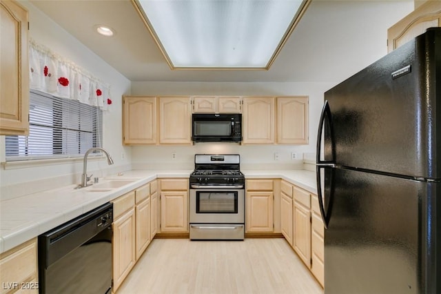 kitchen featuring sink, light brown cabinets, and black appliances