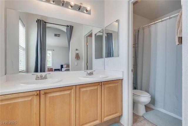 bathroom featuring vanity, toilet, and tile patterned flooring