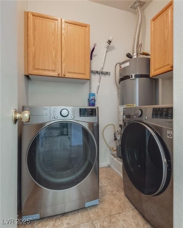 laundry room with washer and clothes dryer, light tile patterned floors, and cabinets