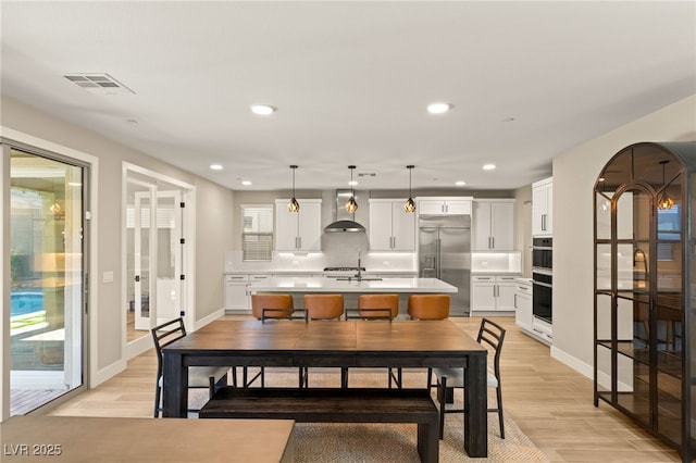 dining area with sink and light wood-type flooring