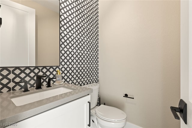 bathroom featuring toilet, tasteful backsplash, and vanity