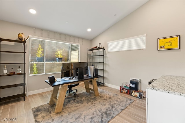 office space featuring vaulted ceiling and light wood-type flooring