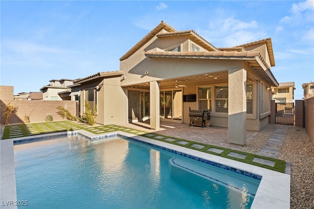 rear view of house with a patio area and a fenced in pool