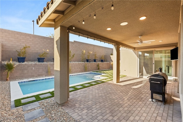 view of swimming pool with ceiling fan and a patio