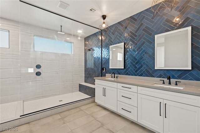 bathroom featuring tile walls, vanity, a tile shower, and tile patterned flooring