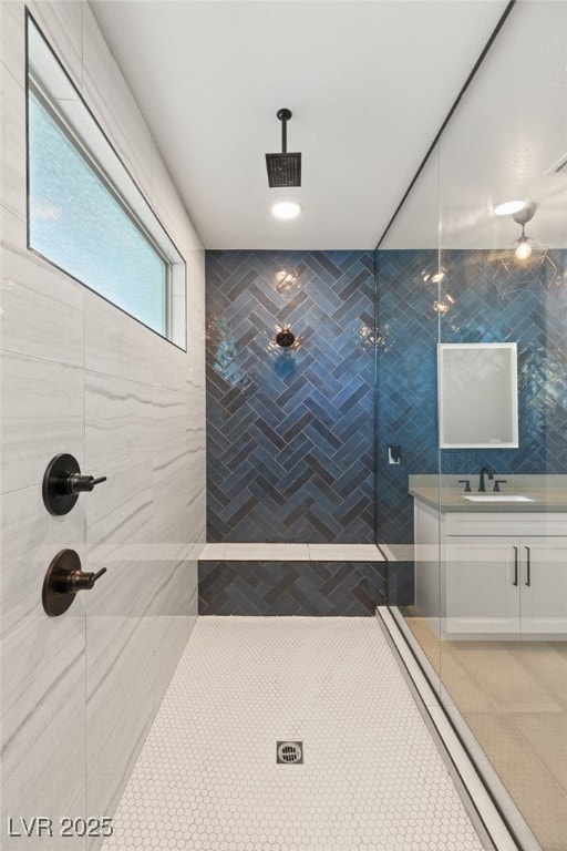 bathroom with vanity, tiled shower, and tile patterned flooring