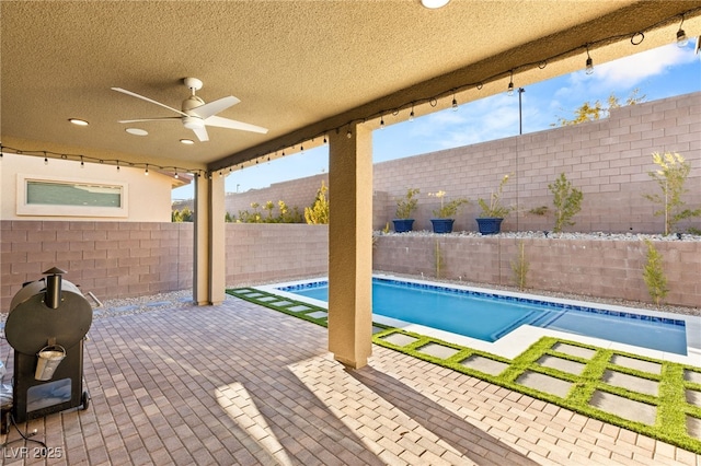 view of pool with ceiling fan and a patio