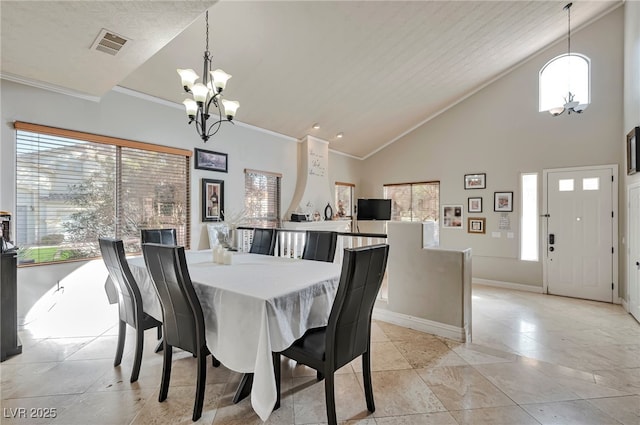 dining area with ornamental molding, high vaulted ceiling, and a chandelier