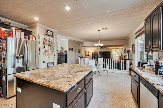 kitchen featuring a kitchen island, hanging light fixtures, ornamental molding, light stone counters, and stainless steel appliances