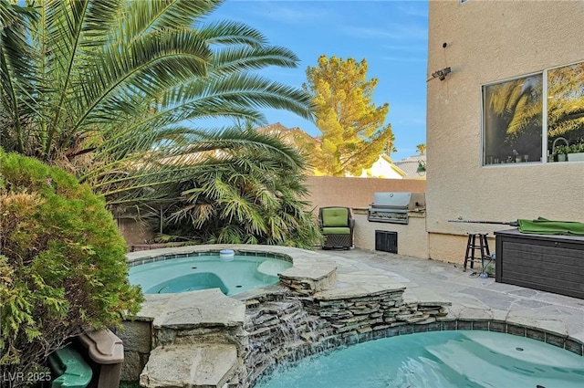 view of pool with an in ground hot tub, an outdoor kitchen, a grill, and a patio