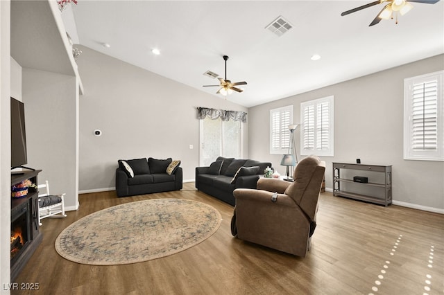 living room with hardwood / wood-style floors, a wealth of natural light, and lofted ceiling