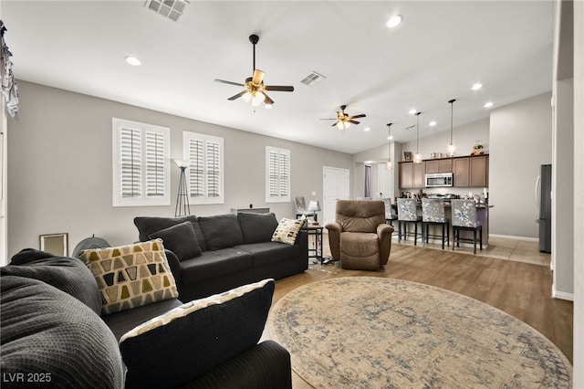 living room with lofted ceiling, light hardwood / wood-style flooring, and ceiling fan