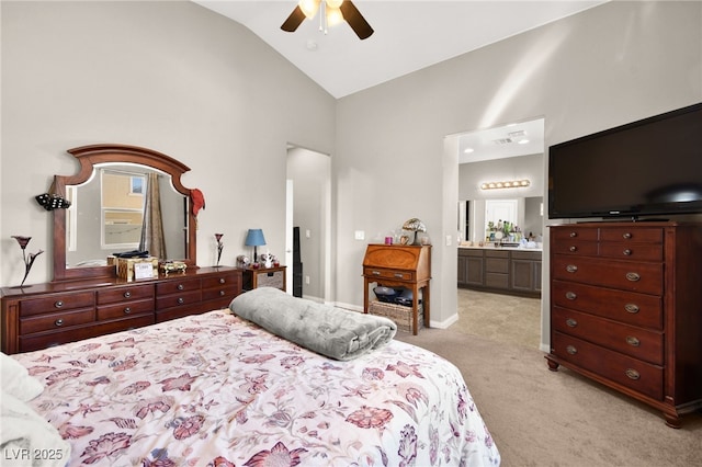 bedroom featuring light carpet, lofted ceiling, connected bathroom, and ceiling fan