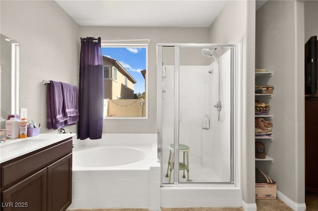 bathroom with vanity and shower with separate bathtub