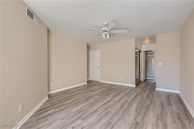 empty room with ceiling fan and light hardwood / wood-style flooring