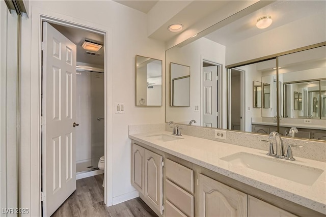 bathroom featuring wood-type flooring, toilet, and vanity