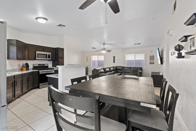 dining space featuring ceiling fan and light tile patterned flooring