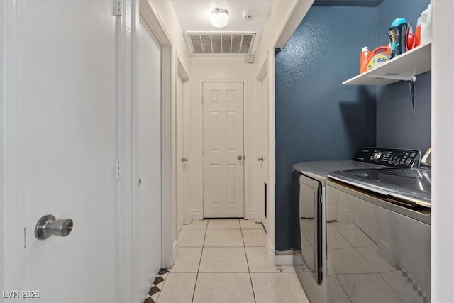 clothes washing area with light tile patterned flooring and independent washer and dryer