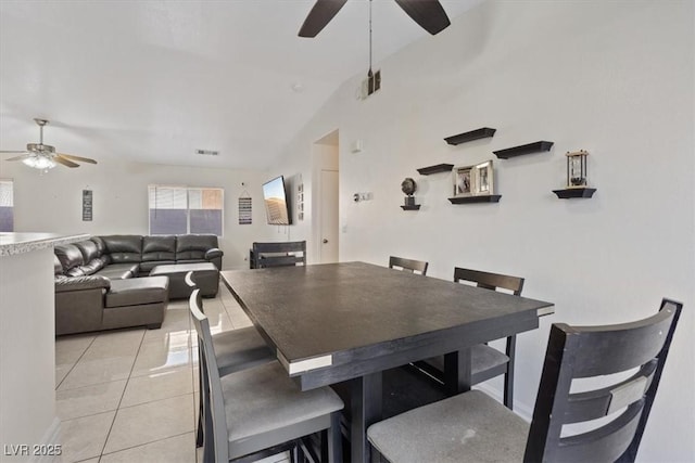 dining space featuring ceiling fan, vaulted ceiling, and light tile patterned floors