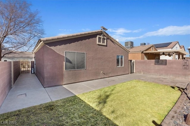 rear view of property featuring a patio area, a lawn, and central air condition unit