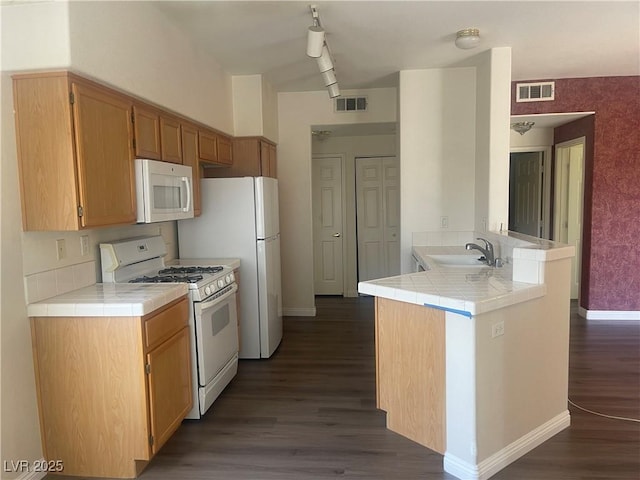 kitchen featuring white appliances, dark wood-type flooring, sink, kitchen peninsula, and tile countertops