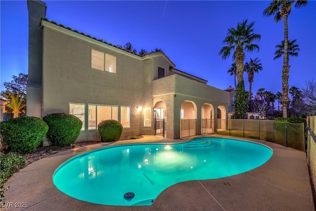 pool at dusk with a patio