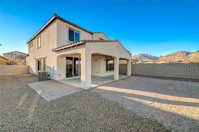 rear view of house featuring a mountain view, a patio area, and central air condition unit