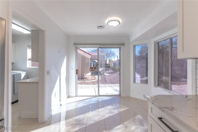 interior space with washer / clothes dryer and light tile patterned floors