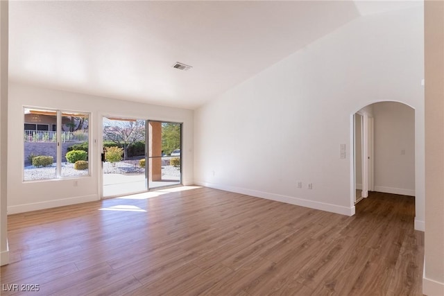 spare room featuring vaulted ceiling and wood-type flooring