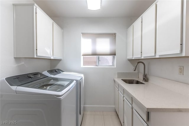 clothes washing area featuring sink, cabinets, washing machine and dryer, and light tile patterned floors