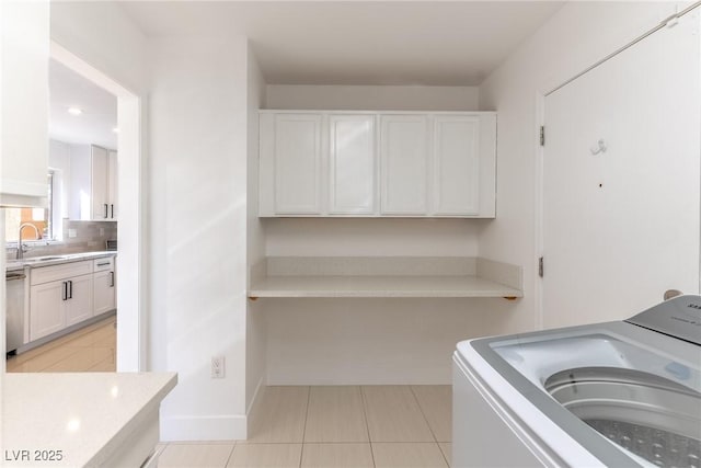 laundry room with sink, washer / dryer, cabinets, and light tile patterned flooring