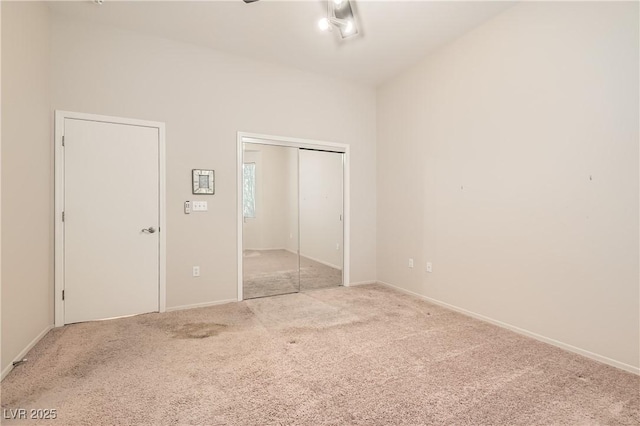 unfurnished bedroom with a closet and light colored carpet