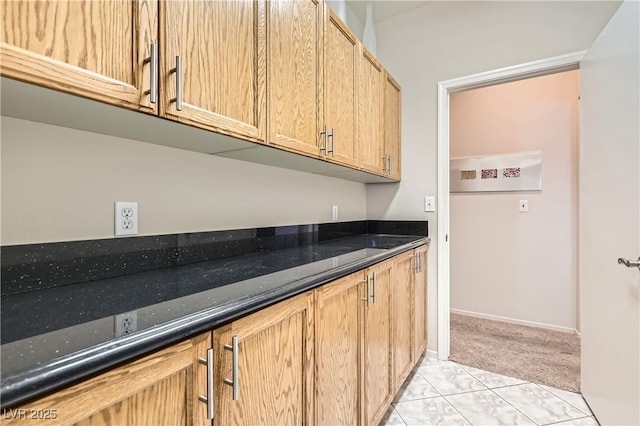 kitchen with light colored carpet and dark stone countertops