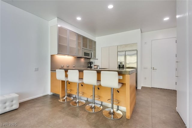 kitchen featuring sink, a breakfast bar, appliances with stainless steel finishes, and kitchen peninsula