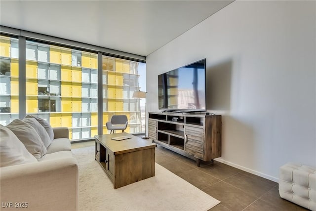 living room with dark tile patterned flooring, a healthy amount of sunlight, and floor to ceiling windows