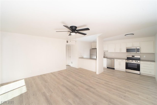 kitchen with ceiling fan, sink, light wood-type flooring, white cabinetry, and stainless steel appliances