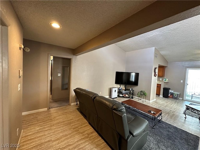 living room with a textured ceiling and light hardwood / wood-style flooring