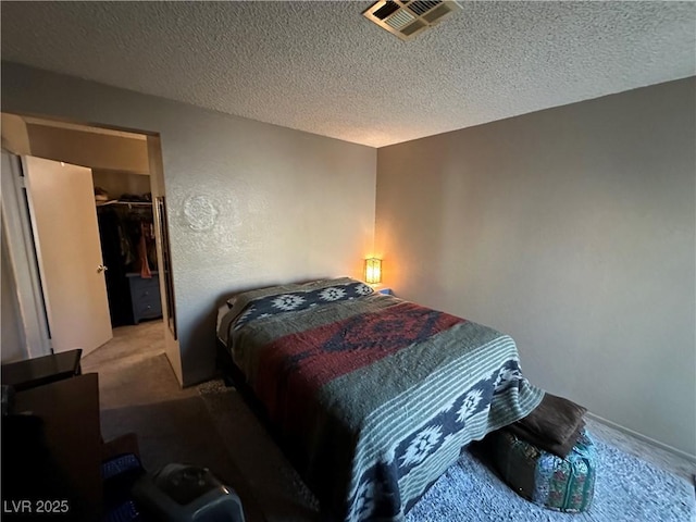 bedroom featuring a textured ceiling, a closet, and a spacious closet