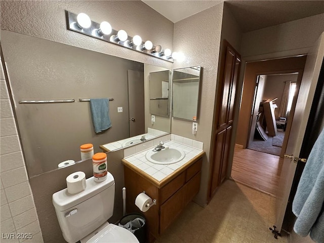 bathroom with wood-type flooring, toilet, and vanity