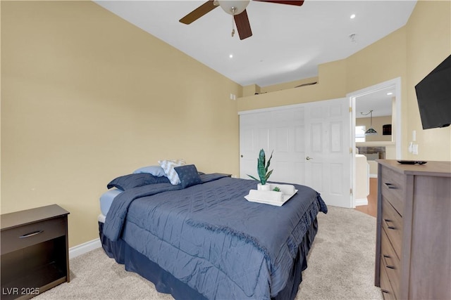 carpeted bedroom featuring ceiling fan, vaulted ceiling, and a closet