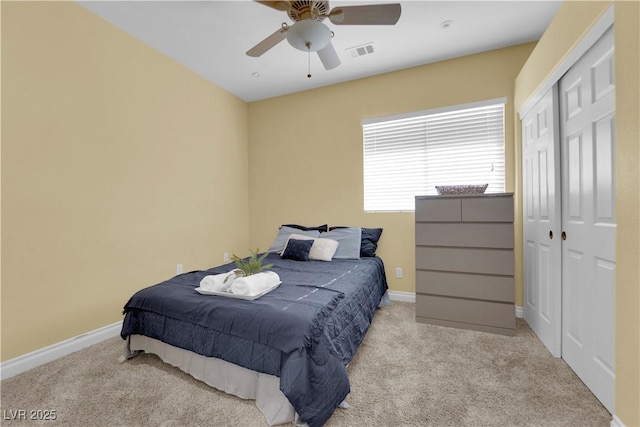 bedroom with light carpet, ceiling fan, and a closet