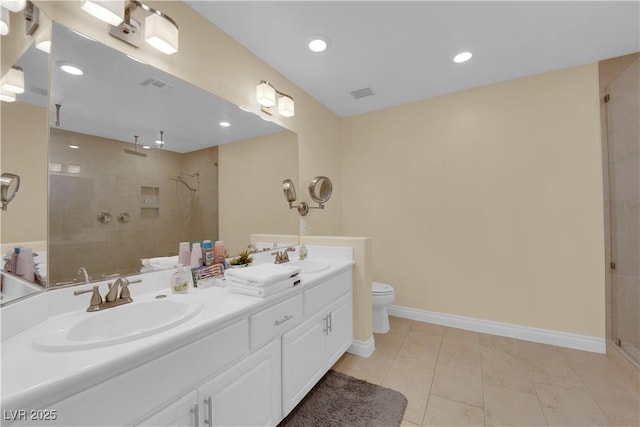 bathroom with vanity, toilet, and tiled shower