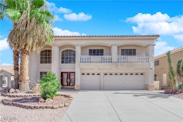 mediterranean / spanish-style house with a garage and french doors