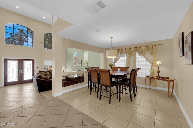 dining room with light tile patterned flooring, plenty of natural light, and french doors