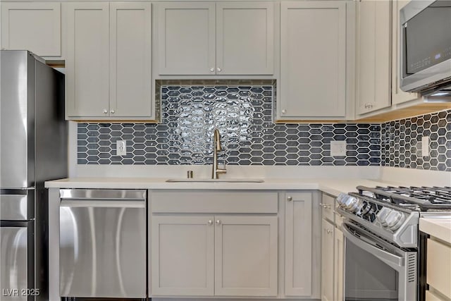 kitchen featuring white cabinetry, appliances with stainless steel finishes, sink, and backsplash